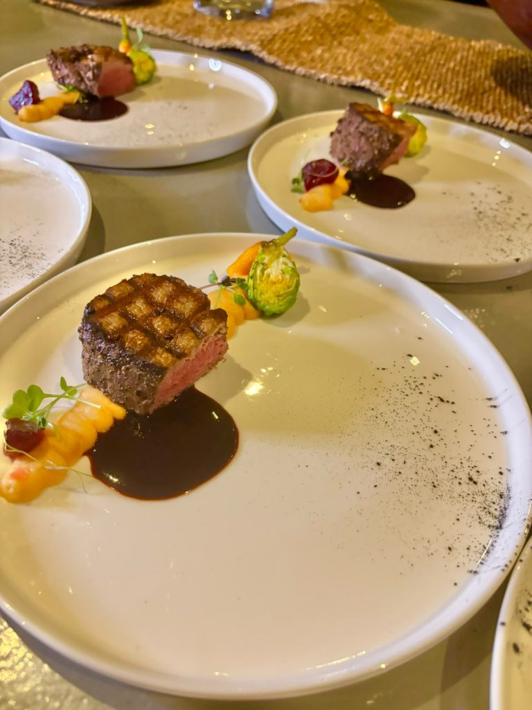 Seared beef fillet with red wine jus, plated for a private dinner service