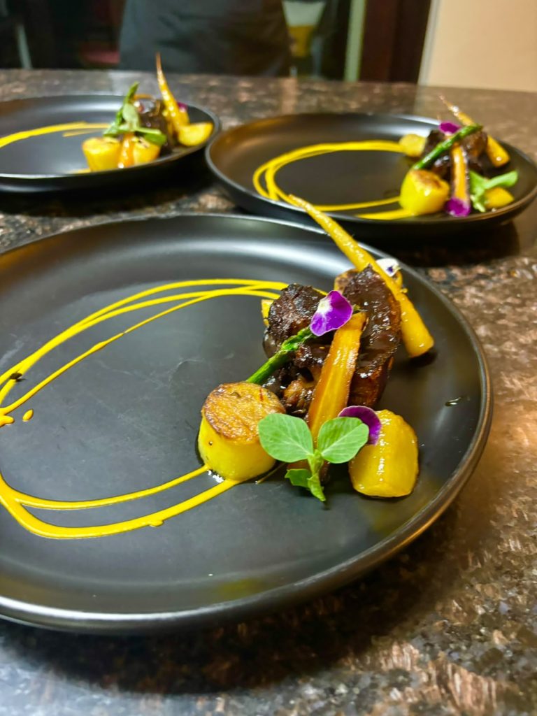 Braised short rib with charred vegetables and a yellow pepper coulis