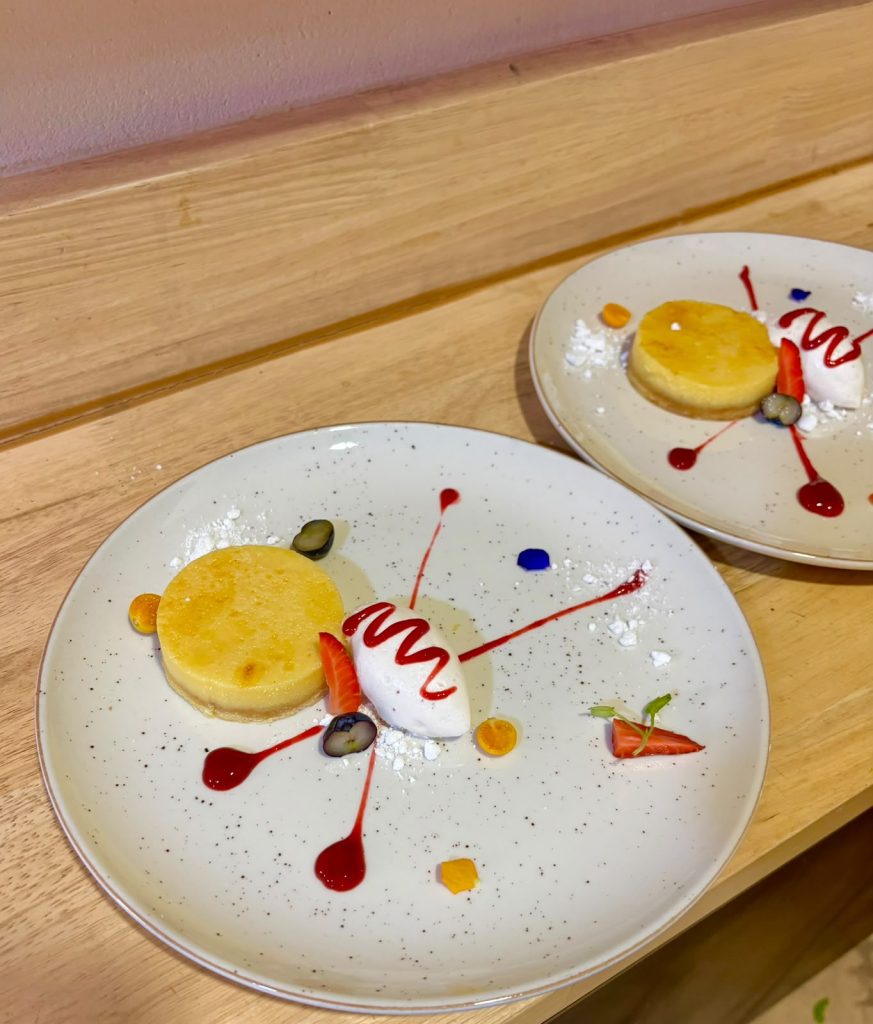 Plated dessert with citrus curd and berry coulis