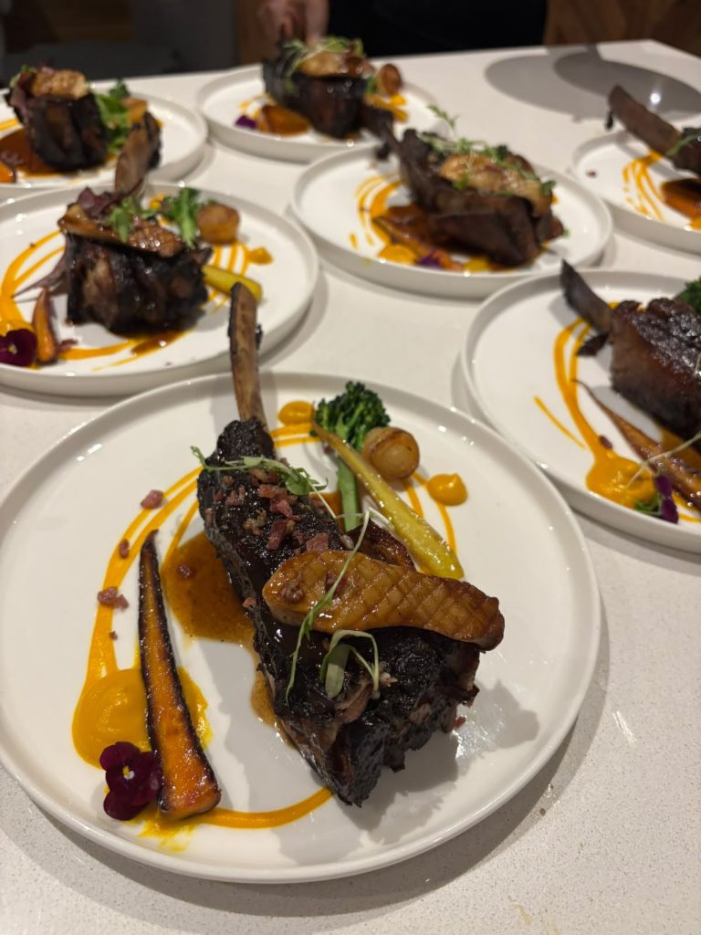 Lamb racks plated in sequence for a seated dinner